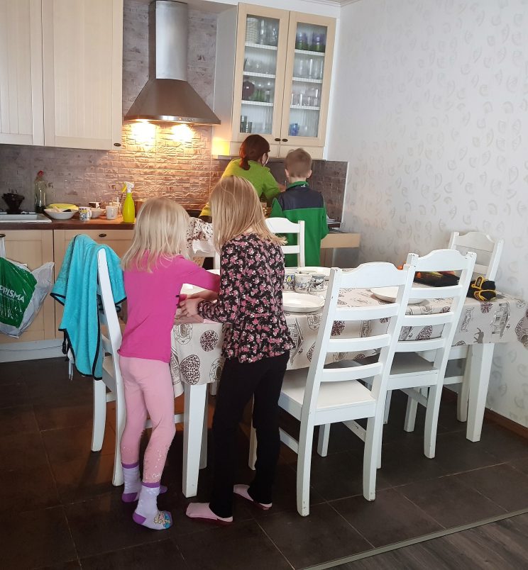 Lunia og Menja dekker bord, mens Johanna lager mat